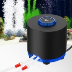 A black aquarium air pump near a fish tank.