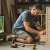 A man is customizing aquairum stand for his fish tank.